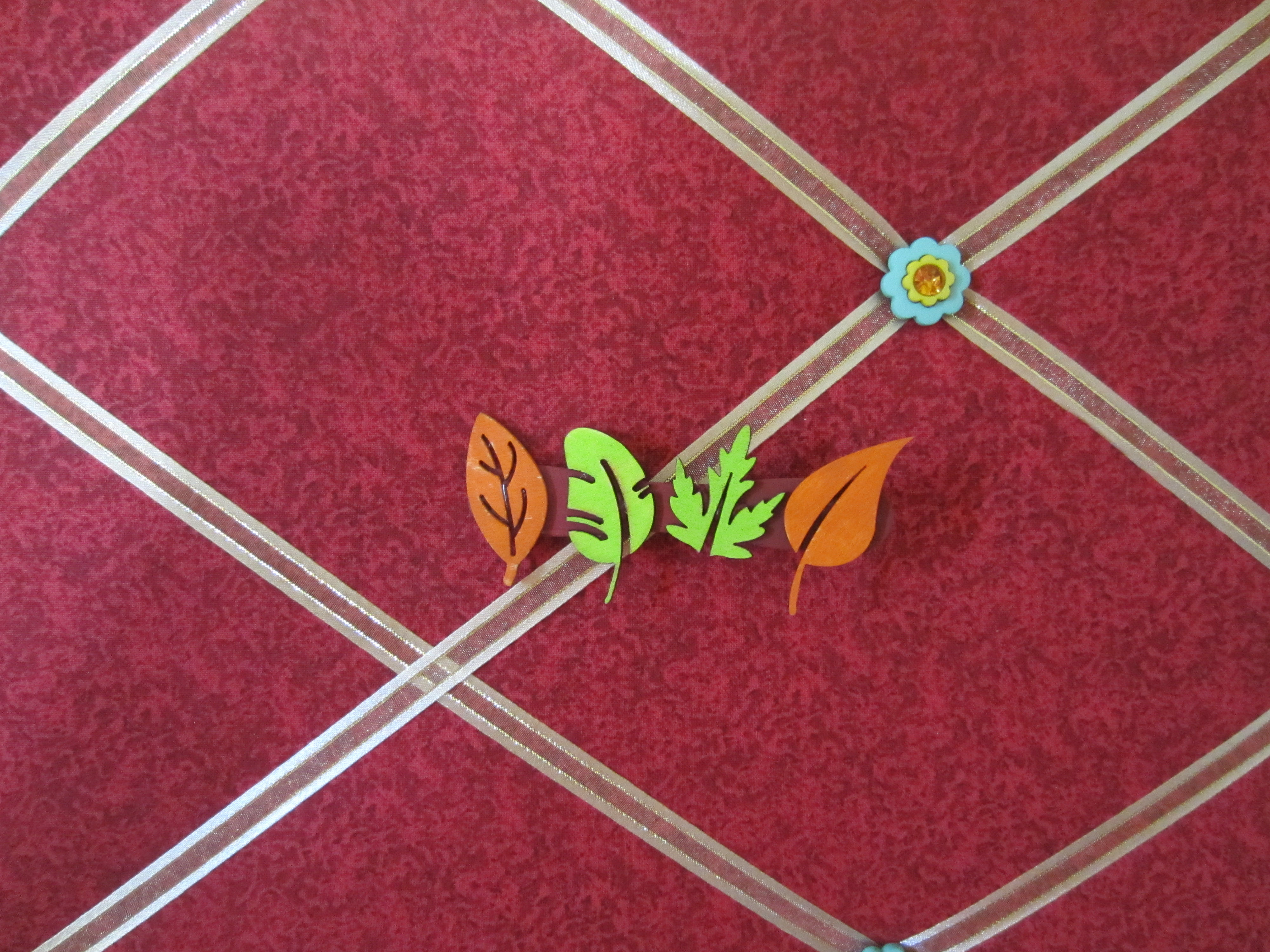 Green and Orange Wood Leaves on Dark Red Background
