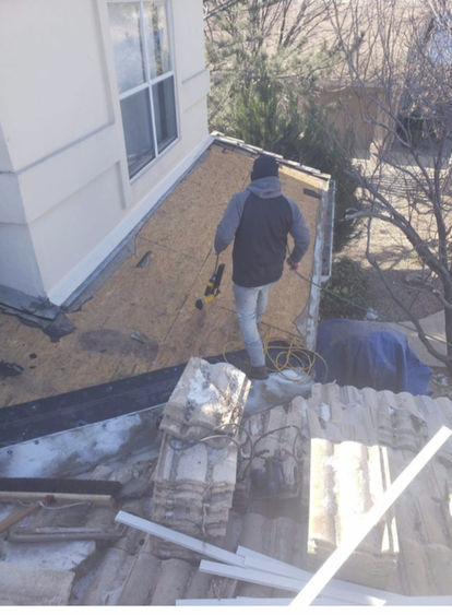 Man working on roof, wearing jacket and hat. Roofing Services, Sw Roofing.