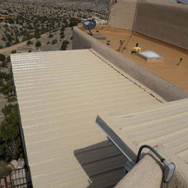 Metal roof with ridge cap and a view of vast desert landscape. SW Roofing