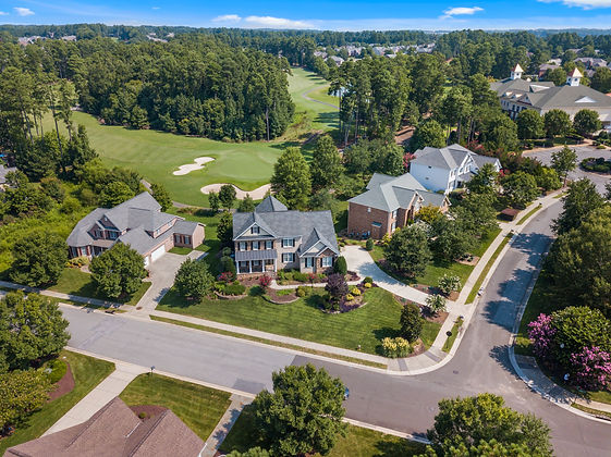 Aerial shot showcasing suburban homes and lush greenery in Raleigh, NC.