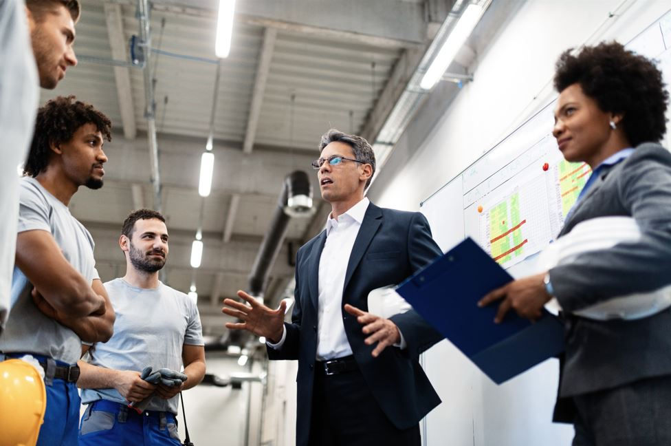 manager holding meeting talking his employees about project plans