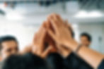 many happy business people raise hands together