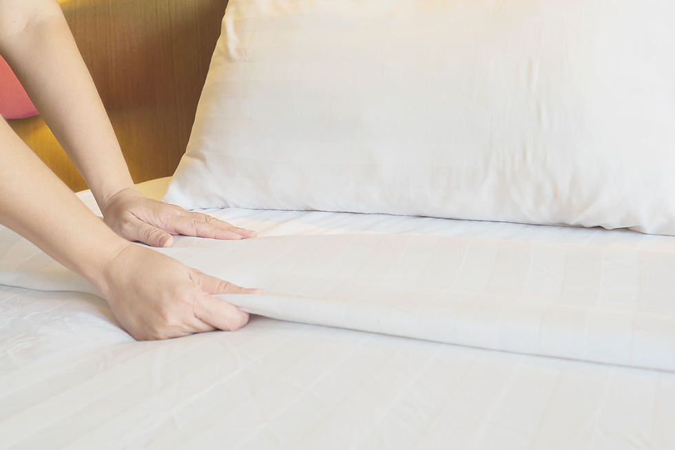 lady hands set up white bed sheet hotel room