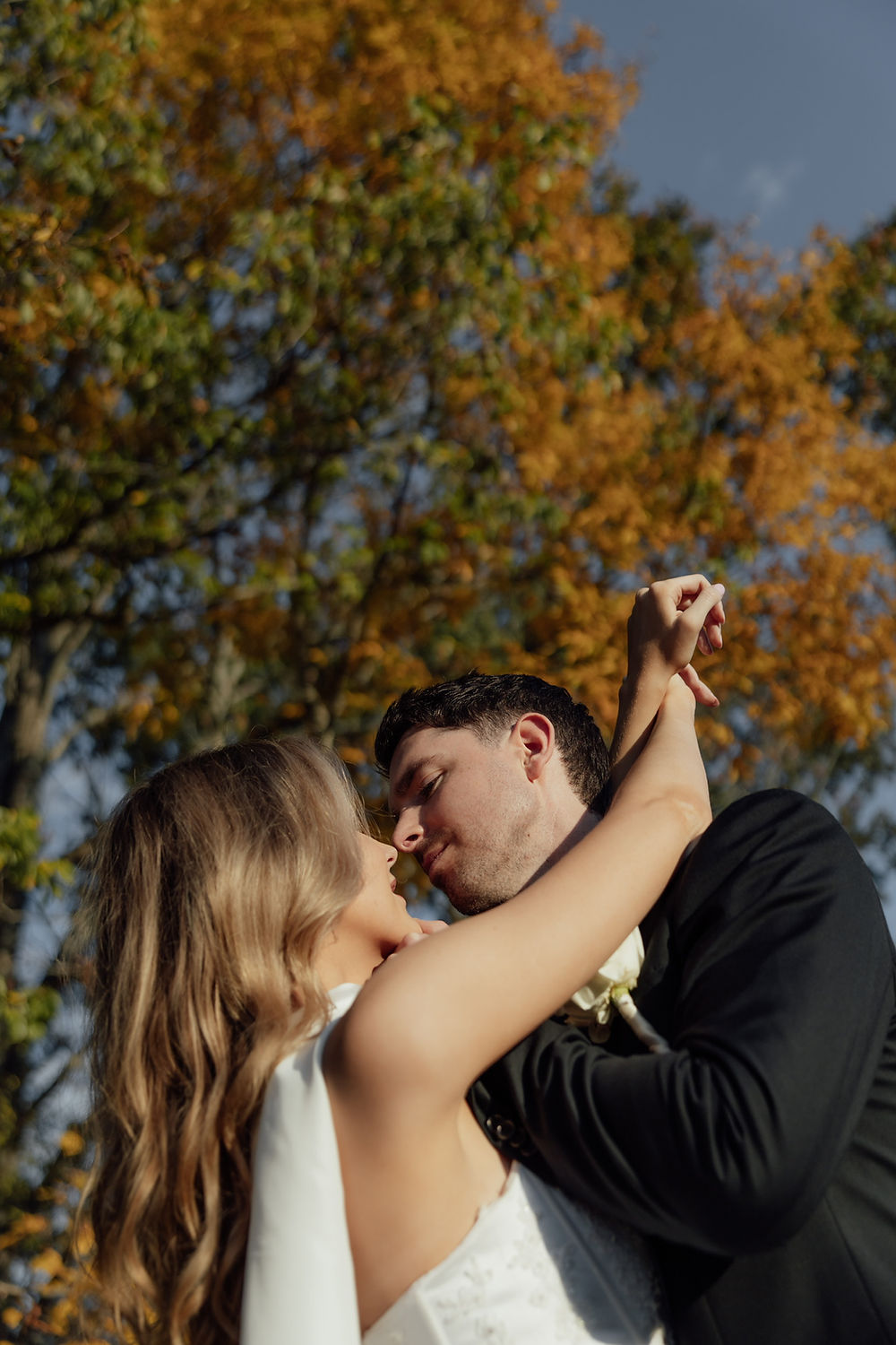 Bride and groom embracing at autumn wedding