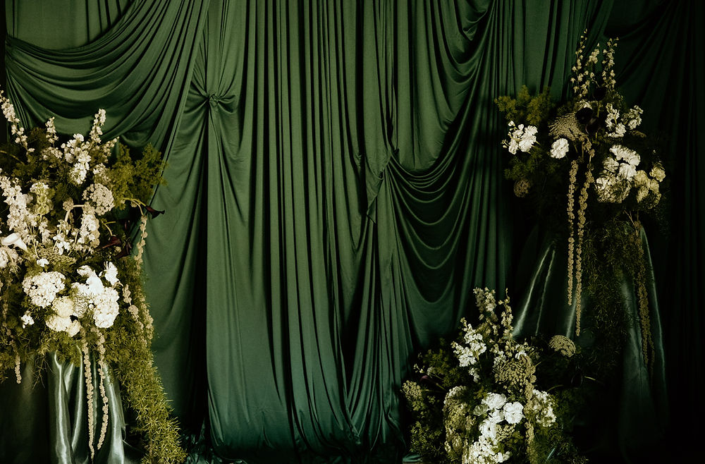 Green wedding drapes with white floral decor