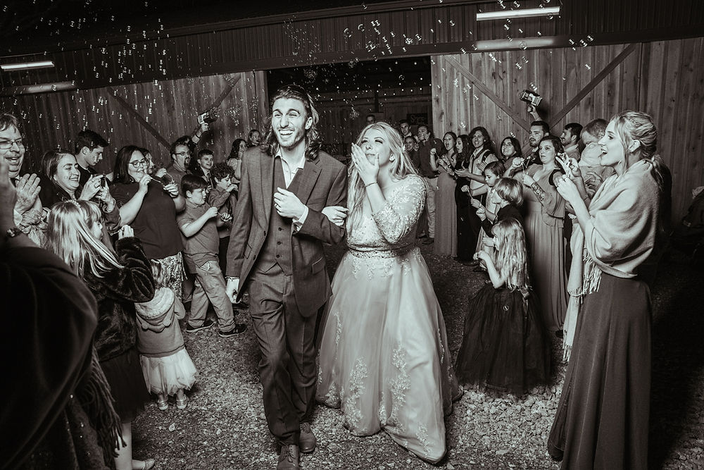 Analea wedding co. couple walk through cheering guests