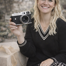Woman smiling while holding a Camp Snap Pro digital camera