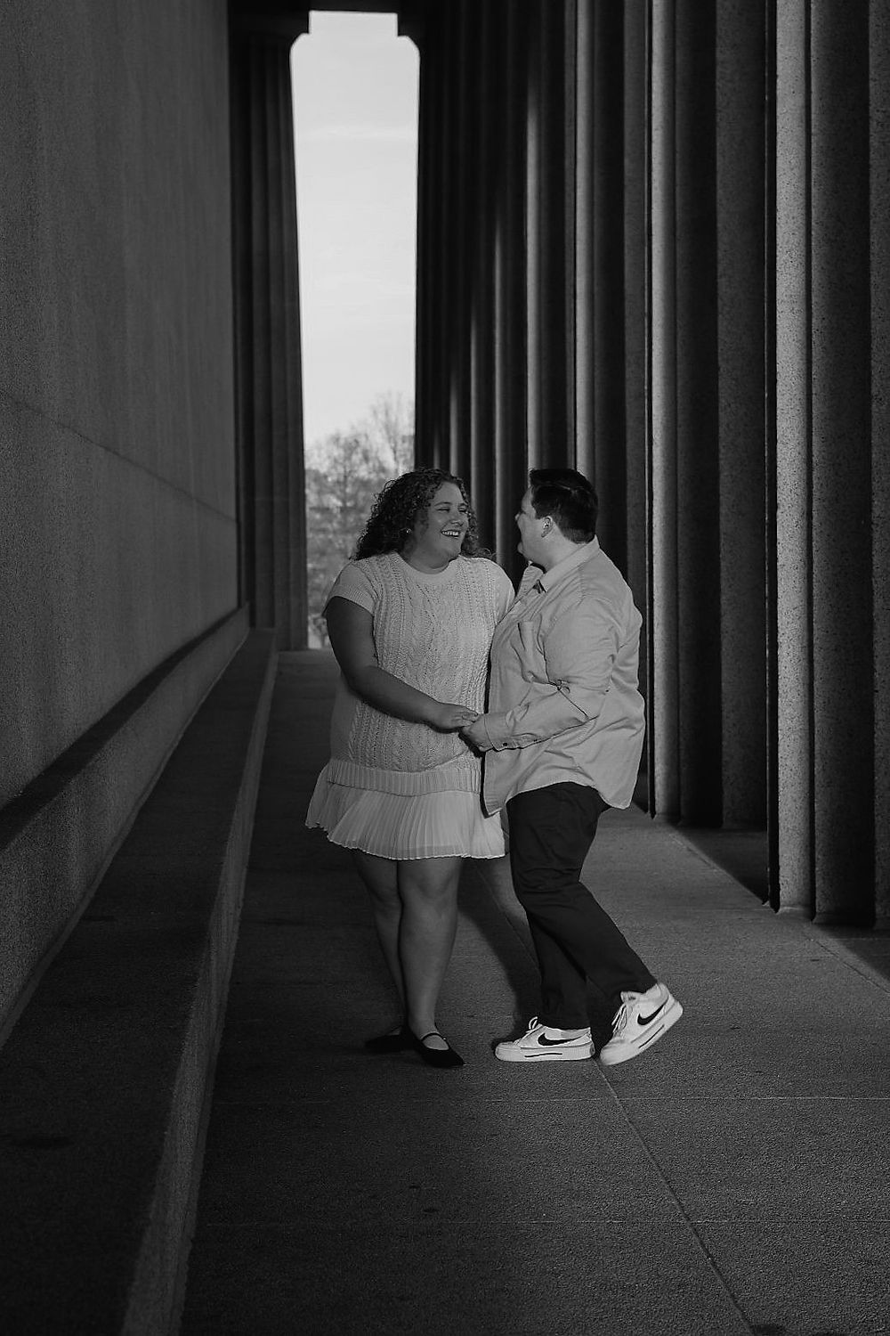 Couple holding hands in colonnade, Analea Wedding Co.