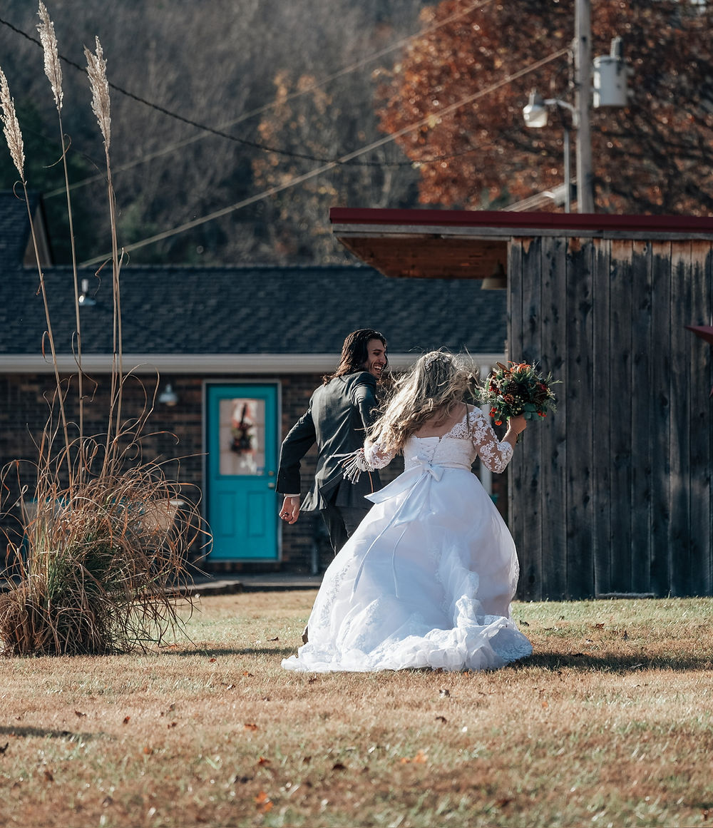 Bride and groom walking in a rustic outdoor setting