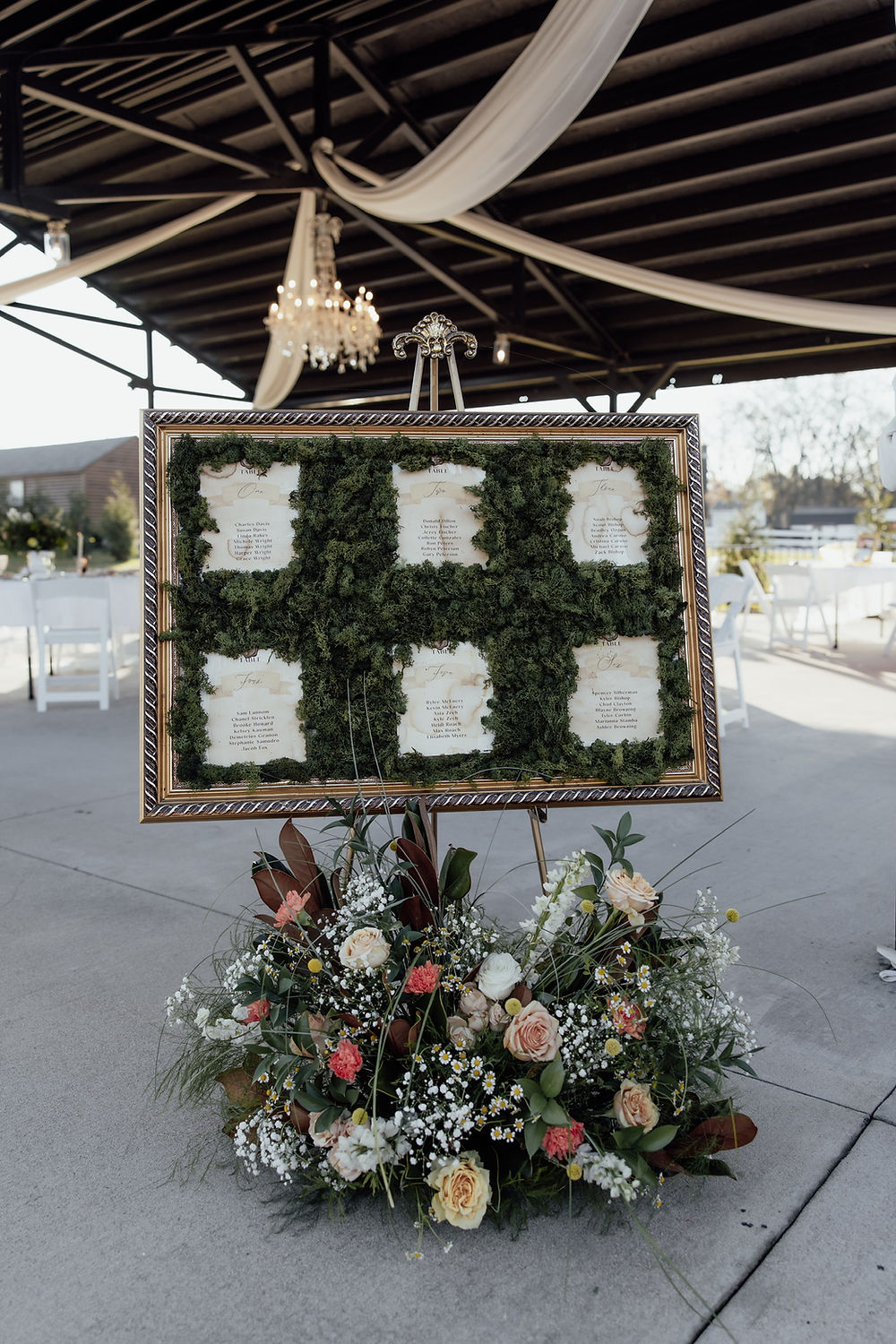 Analea Wedding Co. seating chart with greenery and flowers