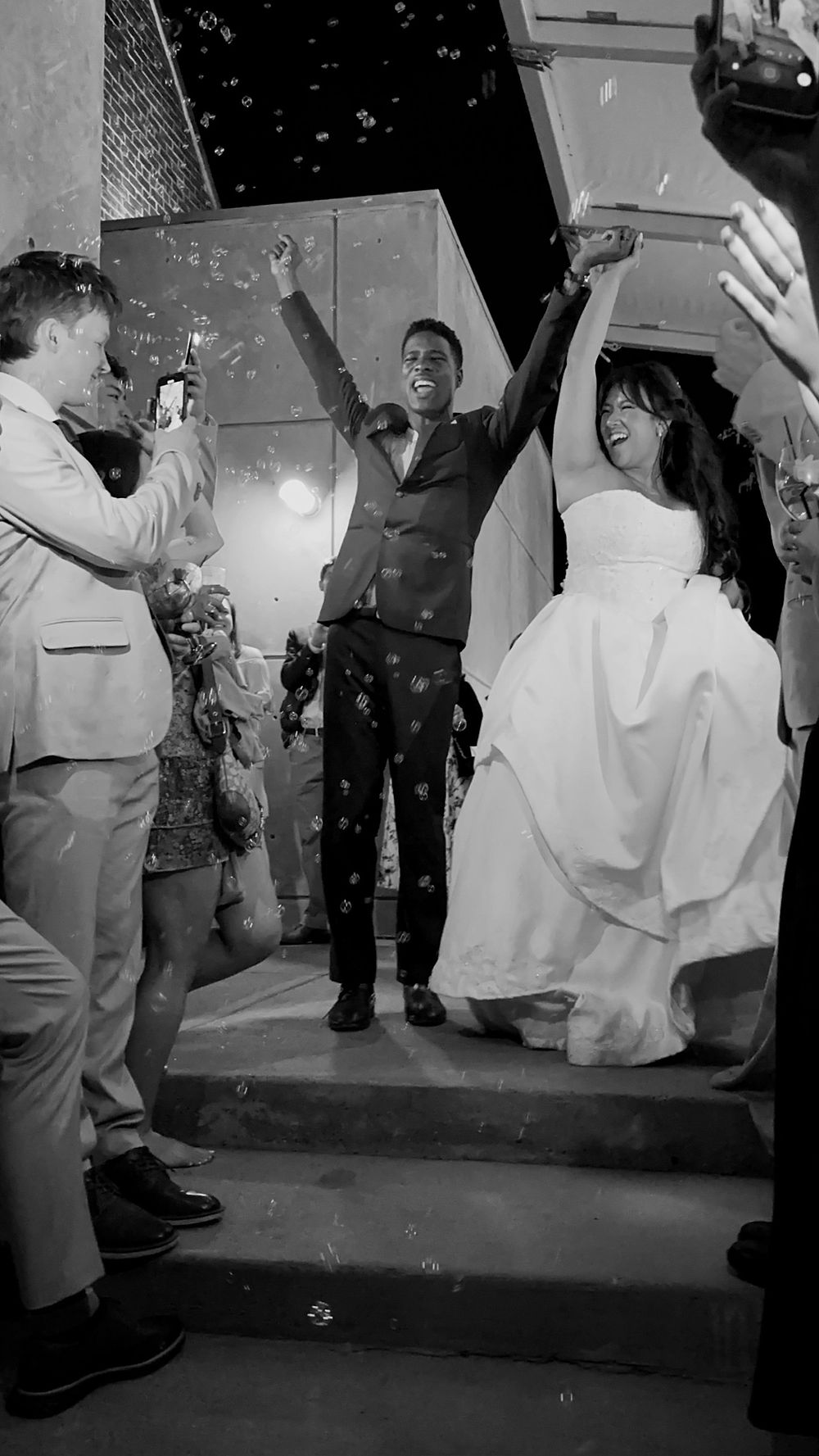 analea wedding co. couple raises arms as confetti falls