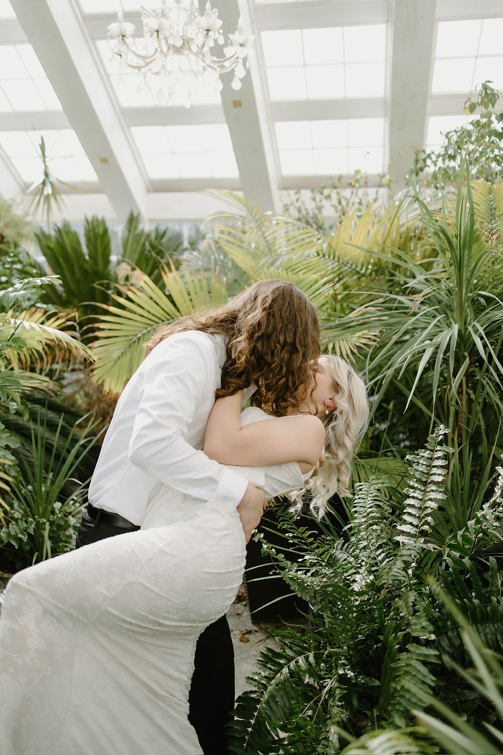 Couple kissing at their wedding in a botanical garden