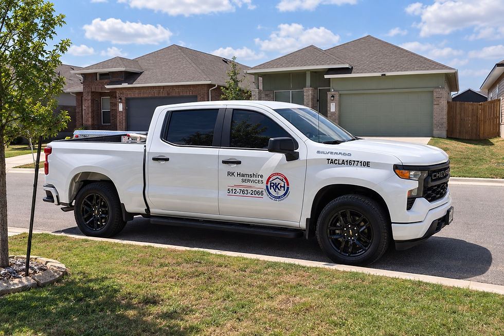 Branded white RK Hamshire Services pickup truck parked in a residential neighborhood street on a sunny day.