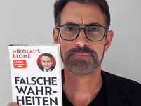 Peter Kreuz mit dem Buch "Falsche Wahrheiten" von Nikolaus Blome