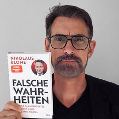 Peter Kreuz mit dem Buch "Falsche Wahrheiten" von Nikolaus Blome