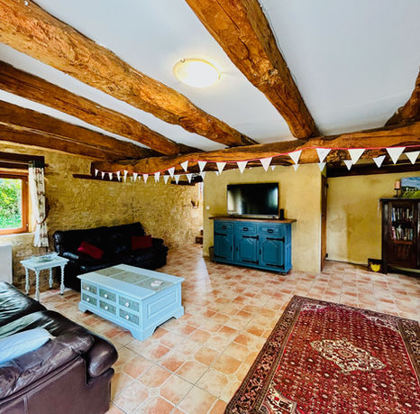 Spacious family room with large smart TV, plenty of sofas and charming beams