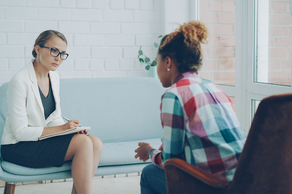 Therapist listening attentively to a young client during a counseling session