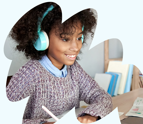 A young girl smiling whilst doing an online tutoring lesson.