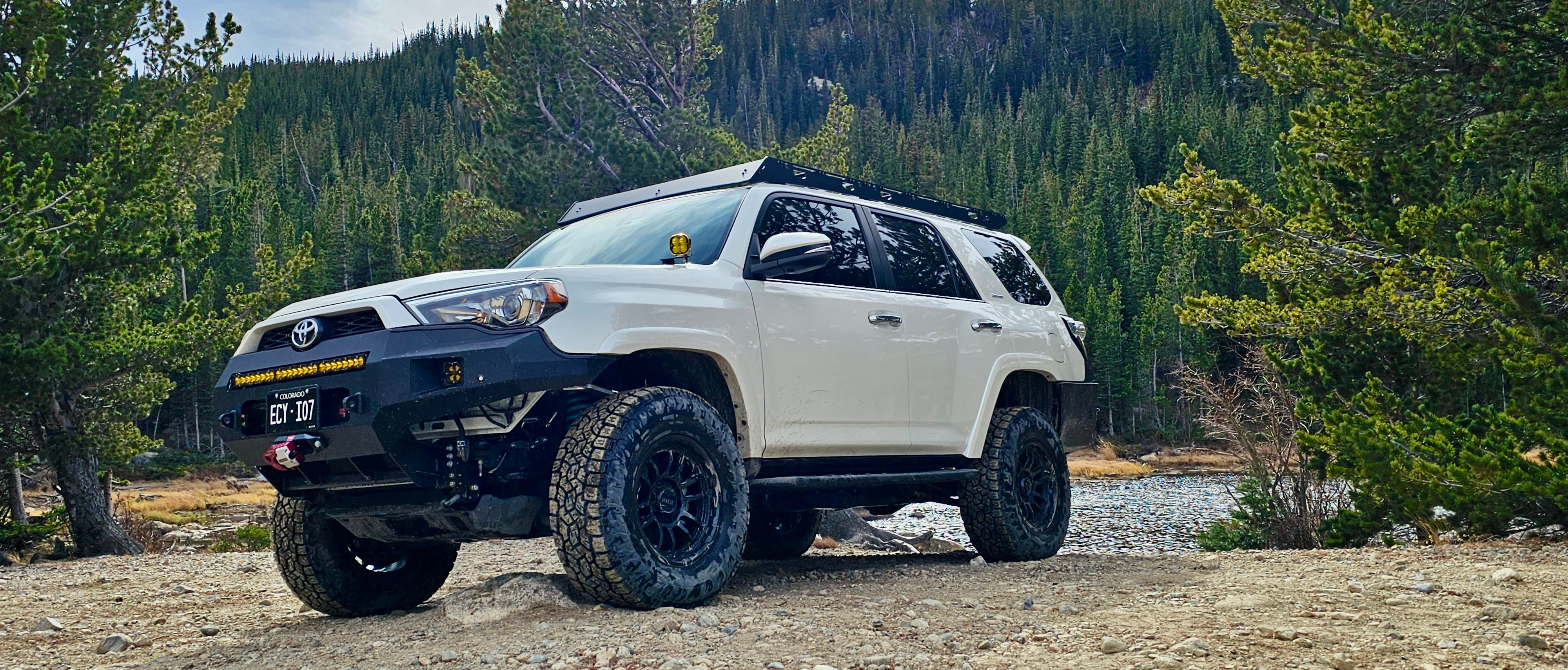 Close-up view of an off-road tire gripping a rock ledge on a technical trail
