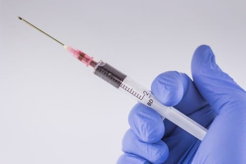 photo of hand holding syringe 