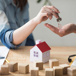 Kaufnebenkosten beim Immobilienkauf mit Taschenrechner und Hausmodell