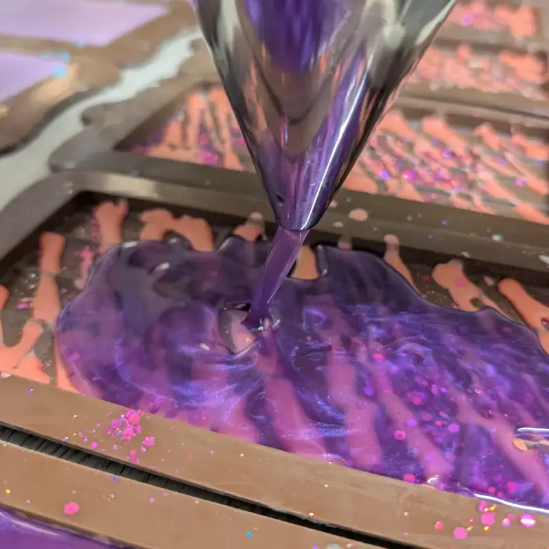 Coulage artisanal de fondants parfumés en forme de tablette avec une composition à base de cire d’olive, cire de colza européenne et cire d’abeille.