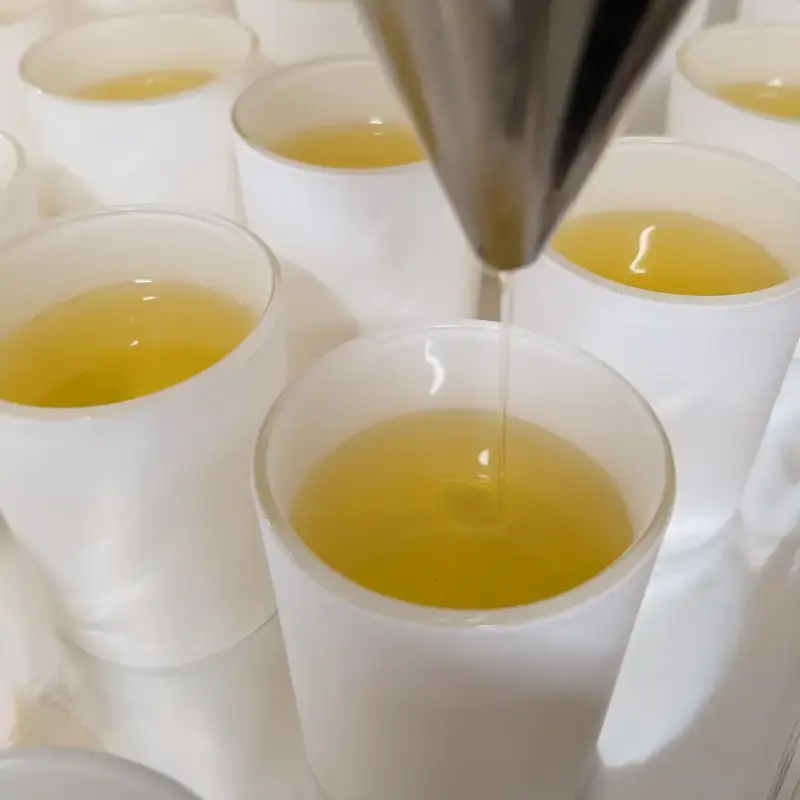 Coulage à la main de bougies parfumées artisanales dans un atelier en Provence, symbole du savoir-faire made in France.