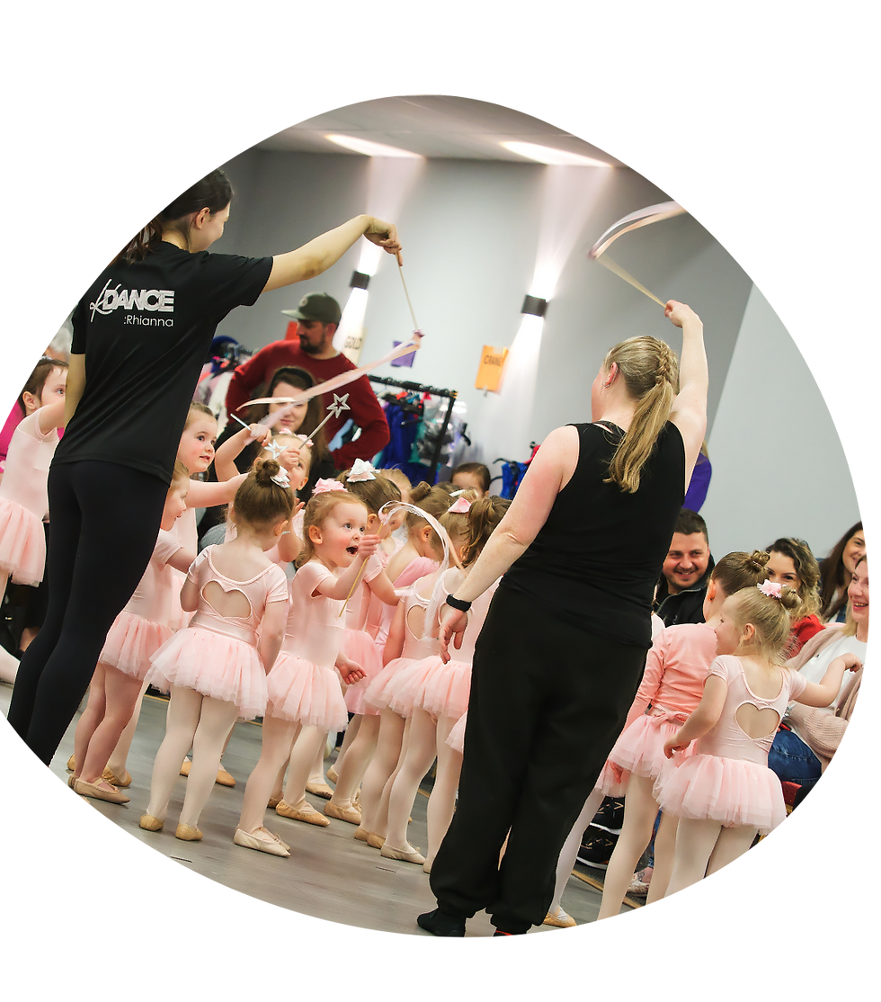 Preschool ballet dancers wave their fairy wands with their dance teachers