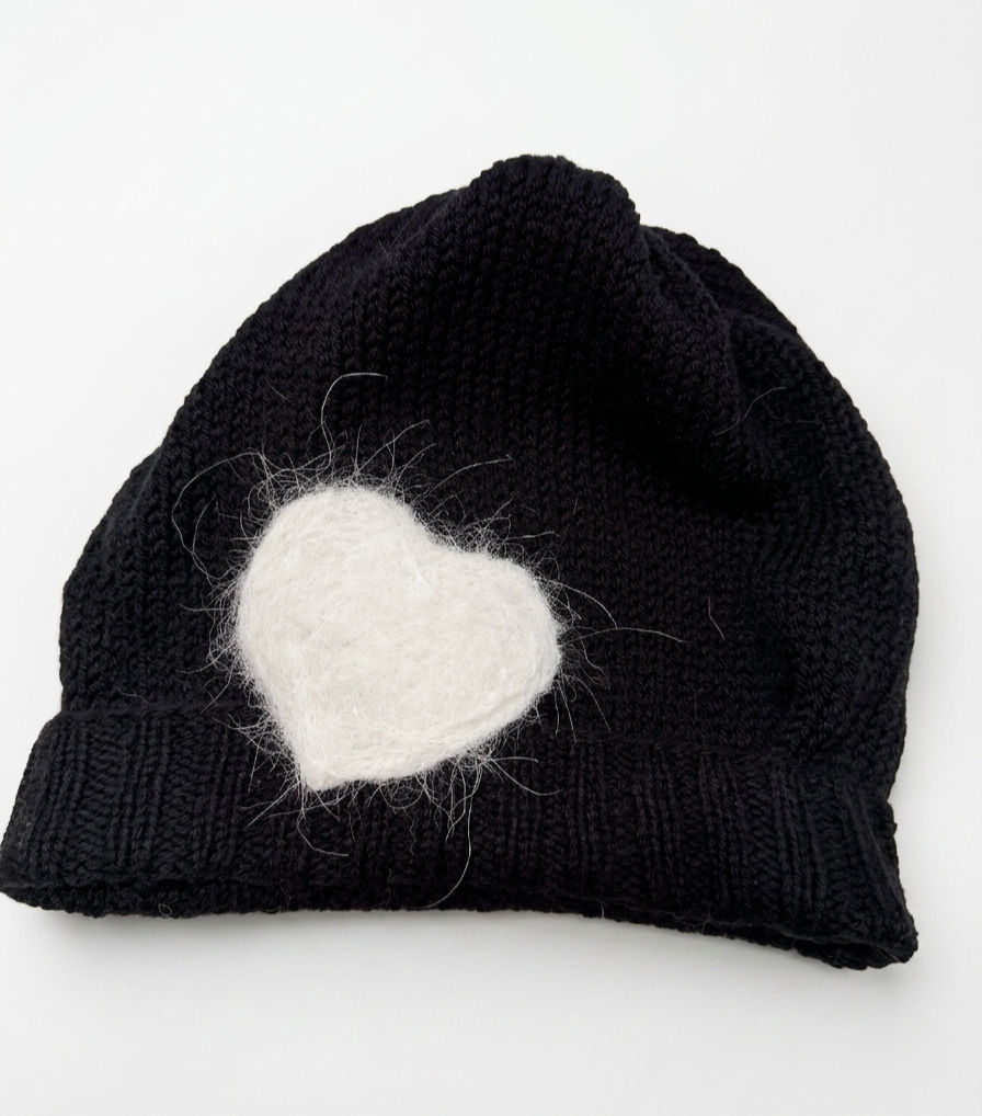 Hand-knit ribbed beanie in natural and black merino wool, artisanal texture, designed for custom pet fiber integration.
