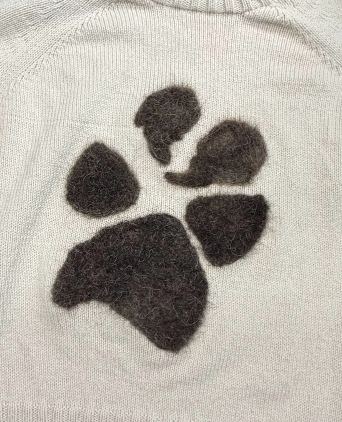 A large, striking felted pet fiber paw print memory motif with deep, fuzzy texture