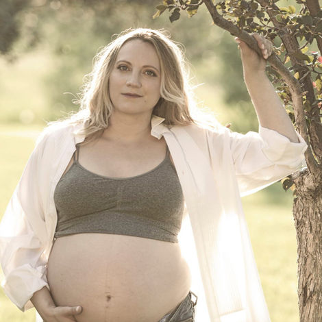 Pregnant lady with belly out with beautiful rim light at edworthy park by calgary maternity family photographer
