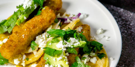 fish tacos with avocado and cilantro placed on a white plate with stale background shot by food and beverage photographer in calgary