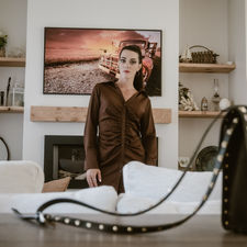 Editorial image of female model and handbag in foreground in living room of a modern home by Calgary editorial photographer