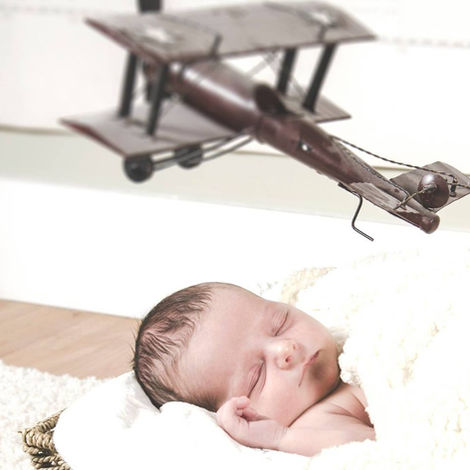 baby in basket with a plane floating above by Calgary family photographer