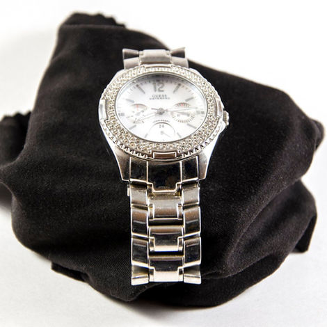 silver mens Guess watch on a black stand with white background shot by product branding photographer in Calgary