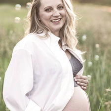 Pregnant lady in field filled with bubbles for maternity photos shot by family photographer in Calgary