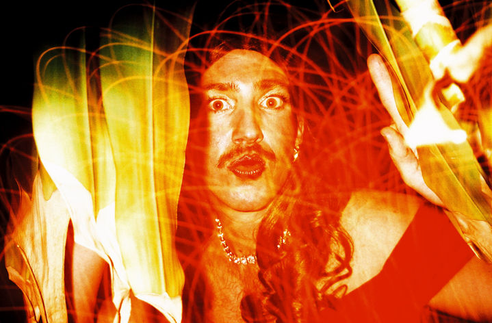 Surprised man with mustache surrounded by orange light trails