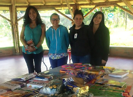 Co-founder Valerie of Kai’s and Cora’s Foundation for Kids stands with three women at Fundación Sinapsis Vital in Colombia. In front of them, a table is filled with essential supplies, representing the foundation’s commitment to supporting children’s healthcare and education.