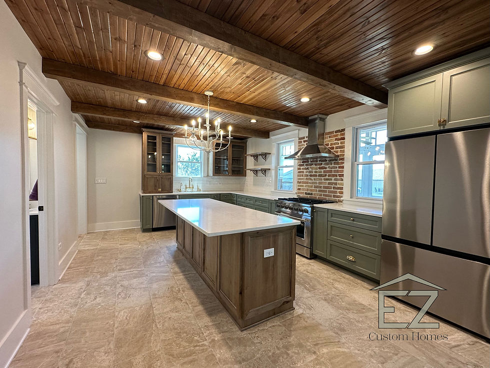 Custom open-concept kitchen with wood beam ceiling, large island, and modern appliances by EZ Custom Homes.