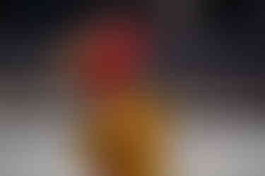 Dos jóvenes músicos vestidos de rojo y amarillo con sus platillos en una gran banda de música