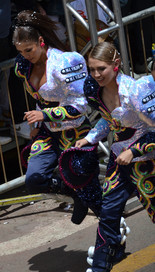 Dos mujeres jóvenes (con pantalones) de una fraternidad de Caporales durante el Carnaval de Oruro