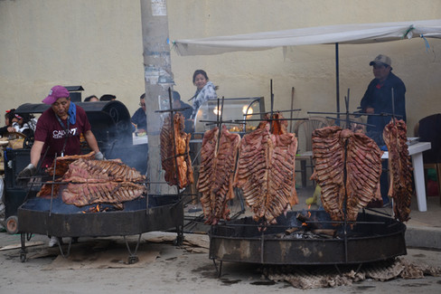 Enormes trozos de cerdo asándose en la calle de Oruro durante el Carnaval de Oruro 2025