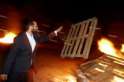 An ultra-Orthodox throws a tree into a fire Lag B'Omer Ashdod Israel 5/15/2016