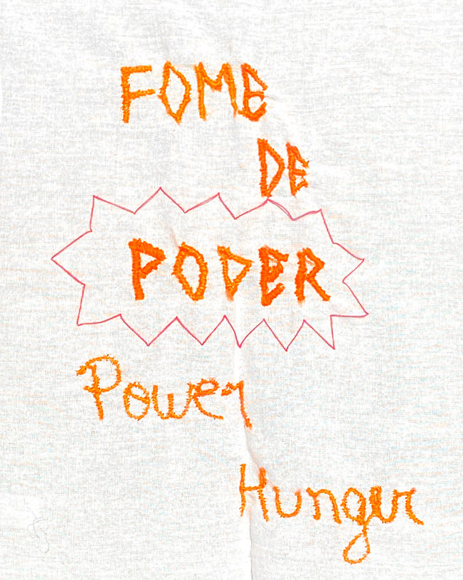 Pano de prato com bordado laranja escrito "fome de poder / power hunger."
