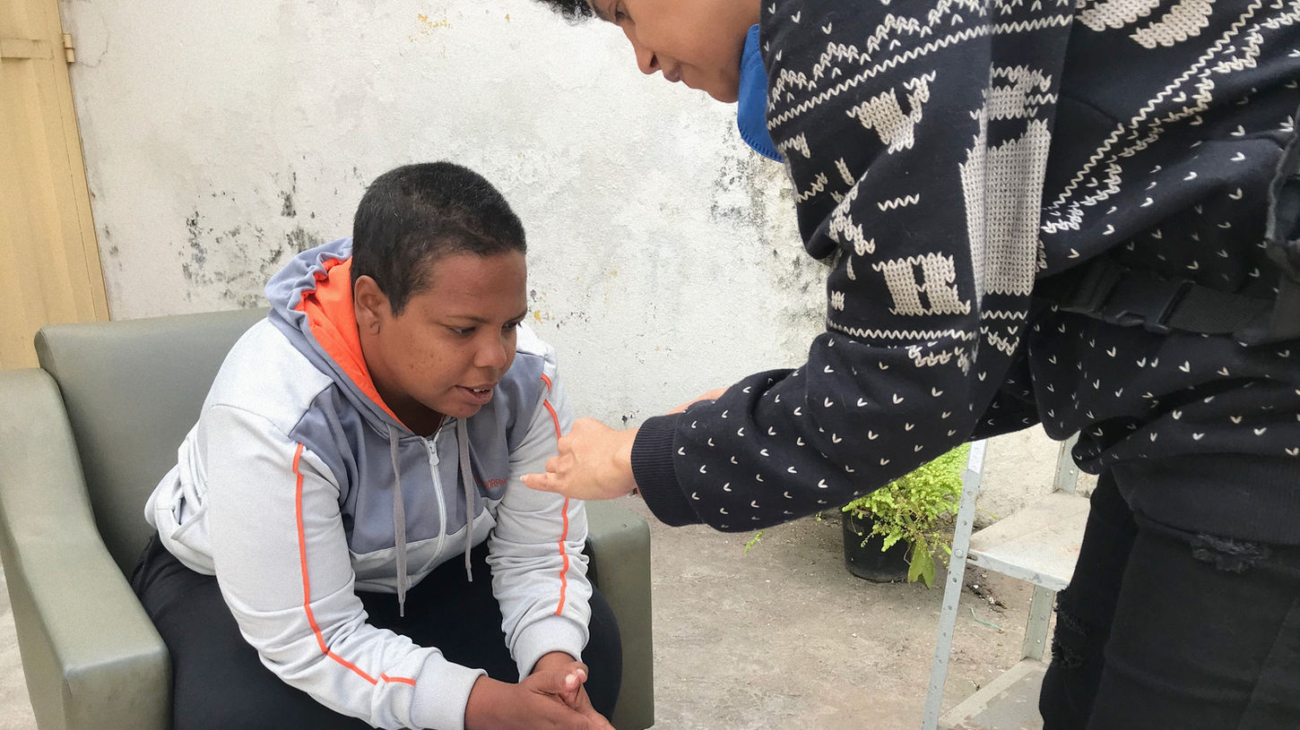 Mulher negra fotografando a mão de outra mulher negra em LABA: Laboratório de Arte e Autonomia realizada pelo QUANDO Coletivo no Abrigo Maria Maria