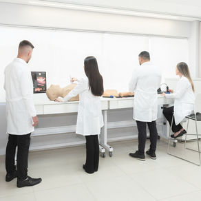 Médico utilizando transdutor de ultrassom em simulador de alta fidelidade durante treinamento prático de POCUS no Instituto Simutec