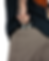 Tattooed hand placing a wallet with cash into brown pants pocket, person wearing a black shirt with orange text. Casual setting.
