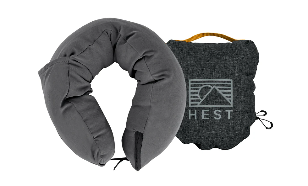 Gray travel neck pillow and a black cushion with a mountain logo and "HEST" text, against a white background. Calm, minimalist design.
