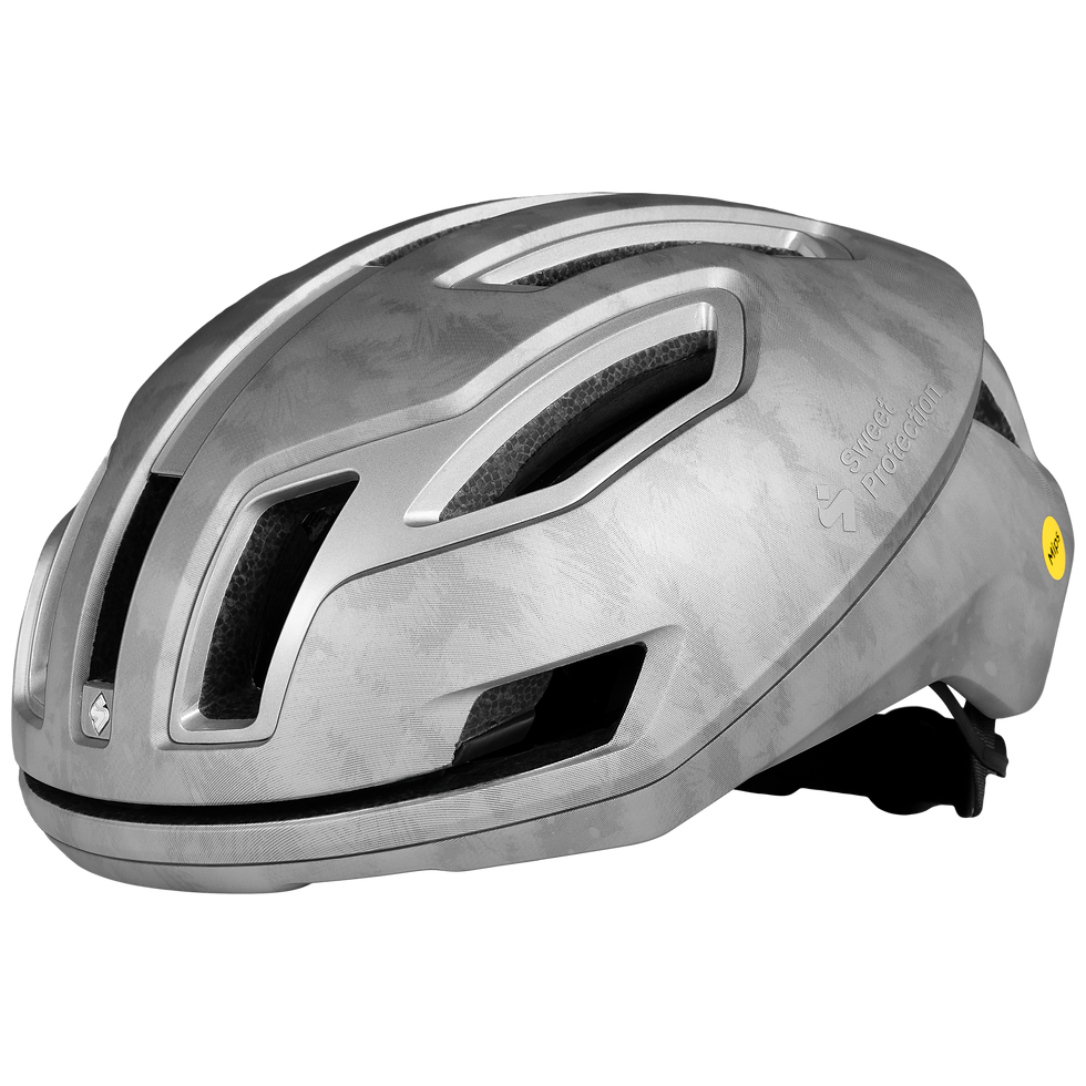 Silver bike helmet with sleek design, prominent vents, and "Sweet Protection" text. Matte finish with black interior padding.
