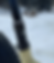 Close-up of a mountain bike fork with thick tire, marked "Travel Adjust," against a snowy forest background. Calm, wintry setting.
